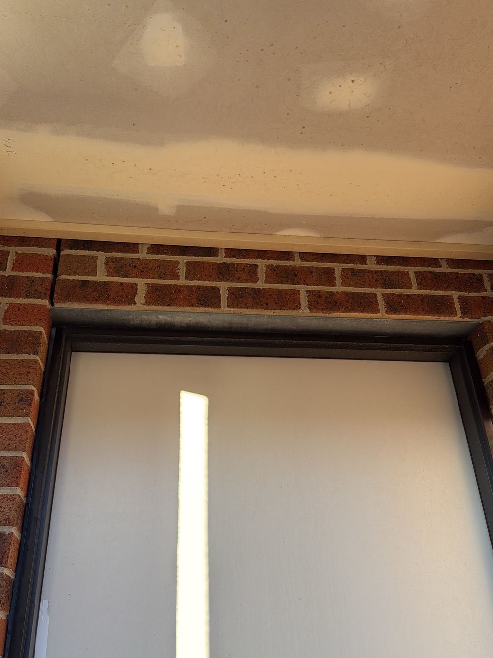 Gaps at the door head and jambs wider than tolerance, needing infill or caulking, found during a fixing inspection in Officer