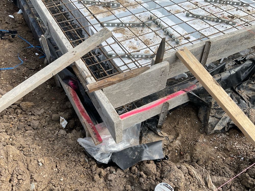 Vapour barrier stopping short of the edge beams instead of running down to ground, found during a slab pre-pour inspection in Officer
